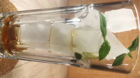 Vertical video. stop motion cold green tea with ice in a glass Video stock 157082377