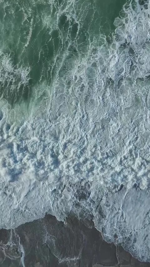 Vertical Video: Stormy Ocean Waves Crashing Into Rocks on a Beach Captured Video stock 342572388