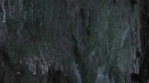 Vertical video, a stream of waterfalls flowing through the rocks. The water is c Stock Footage 210160367