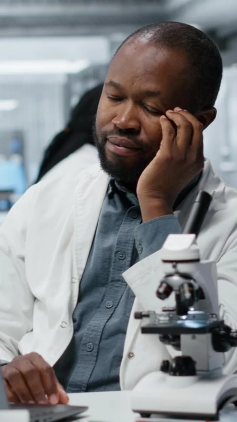 Vertical video Stressed lab chemist feeling overwhelmed while working on laptop Video stock 326366972