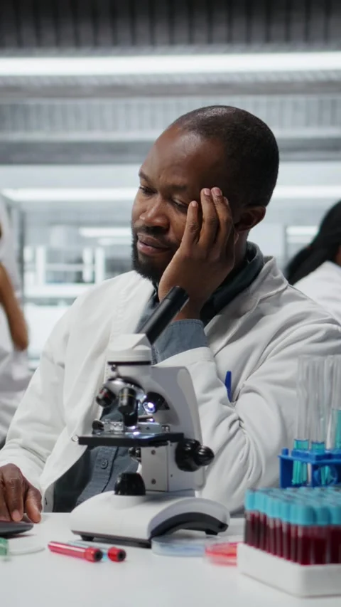 Vertical video Stressed lab chemist feeling overwhelmed while working on laptop Video stock 327415983
