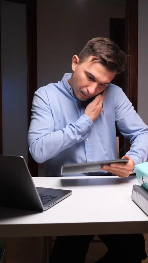 Vertical video Stressed man working overtime multitasking with multiple devices Stock Footage 322911959