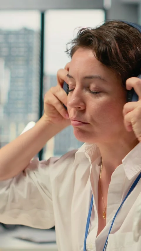 Vertical video Stressed programmer in office listening music to relax while Stock-Footage 323404343