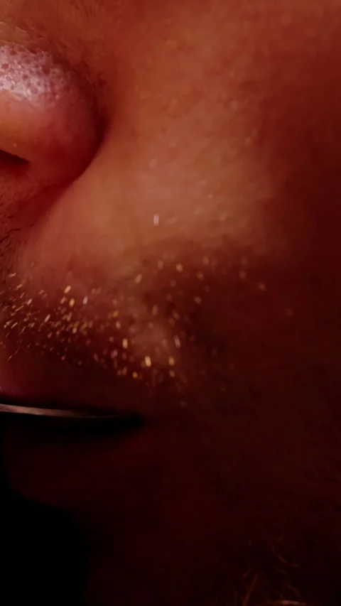 Vertical video. Stubbled Man Tastes Liquid From a Metal Spoon Against Black Back Stock Footage 341982229