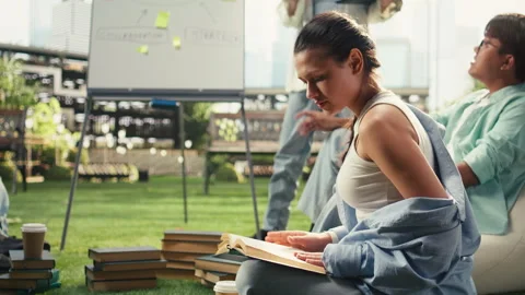 Vertical Video Student reading open book during group study tutoring session Stock Footage 340805070