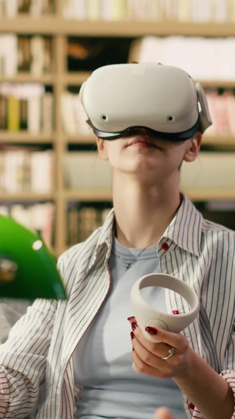 Vertical Video Student using VR device and controller to explore immersive Stock Footage 336380186