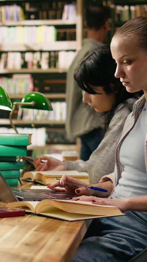 Vertical Video Student writing on textbook and loses focus after receiving phone Stock Footage 336379043