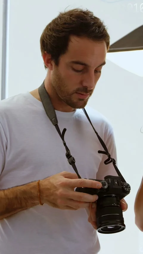 Vertical video: Studio pro tuning DSLR dials on model cue, prepping as bits Stock Footage 333259706