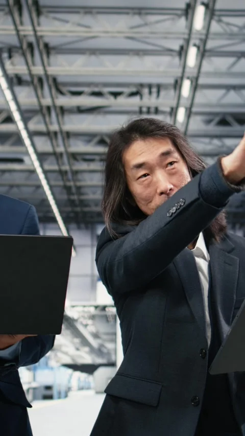 Vertical video Studying manufacturing gear, microchip factory and multiracial Stock Footage 333614887