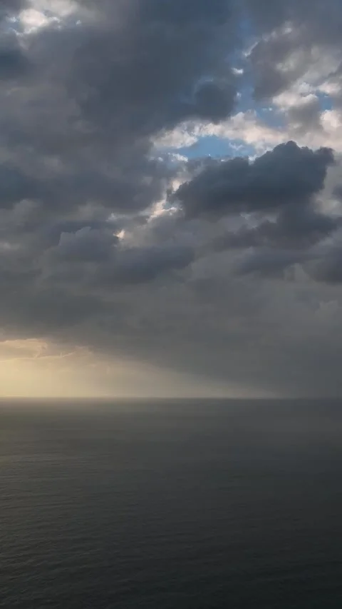 Vertical Video: Stunning Cloudy Sunset Over the Sea with Textured Waves and Stock Footage 297725571