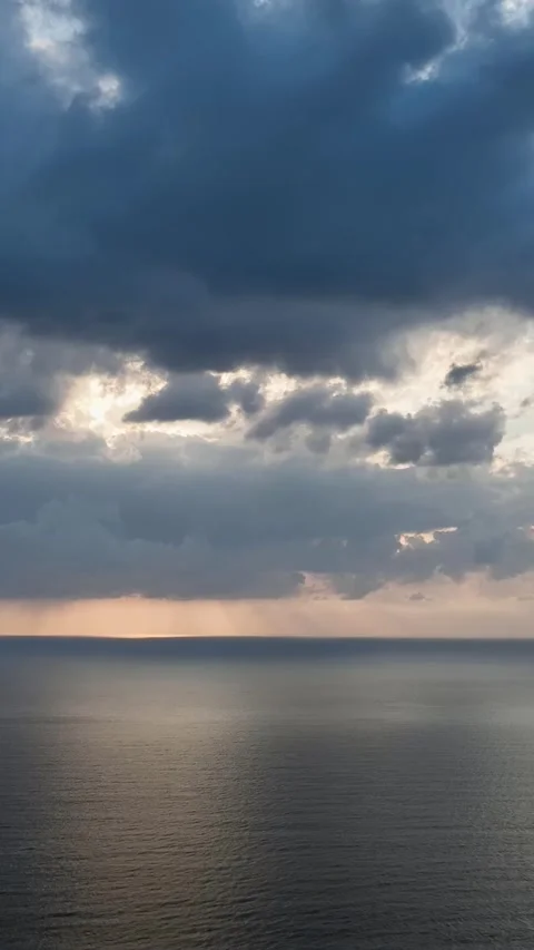Vertical Video: Stunning Cloudy Sunset Over the Ocean with Gentle Waves Stock Footage 297726296