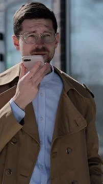 Vertical video. Stylish man making voice message or using virtual assistant.. Stock Photos