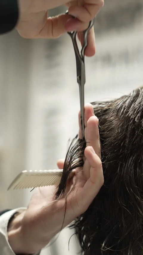 Vertical video: Stylish man sitting barbershop hairdresser woman cutting hair Stock Footage 271584266