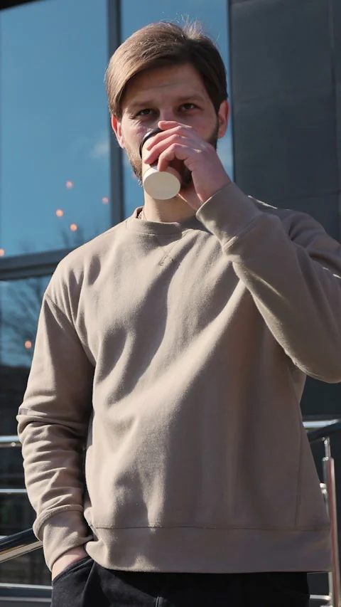 Vertical video. Stylish young man enjoying coffee while strolling Stock-Footage 344108646