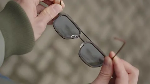 Vertical video. Sunglasses in the hands of a man. POV video Stock Footage 316319371