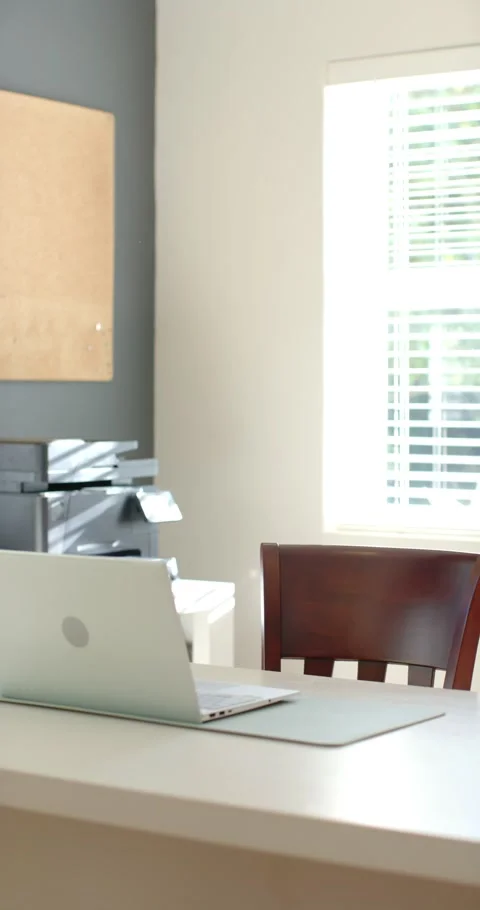 Vertical video: Sunlight shining through blinds is shifting shadows across desk Stock Footage 345092685