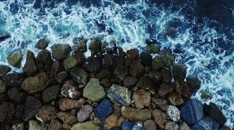 Vertical video, a surfer launches from the rocks into the sea. Aerial video N. Stock Footage 63798997