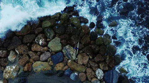 Vertical video, a surfer on the rocks with waves. Aerial drone video N. Stock Footage 63796613