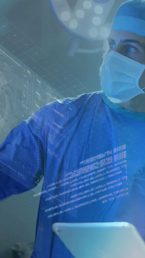 Vertical video: Surgeon tapping tablet as nurse handing device, showing 3D Stock Footage 334770773