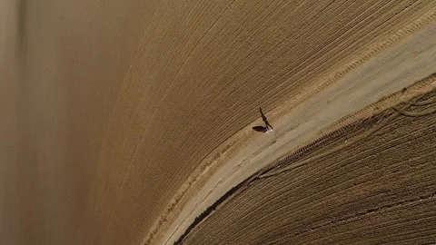 Vertical video. The SUV moves between the fields bypassing a woman pedestrian. Video stock 268879373
