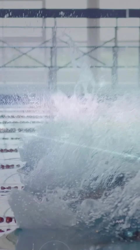 Vertical video: Swimmers launching on start signal diving from blocks and Stock Footage 331047224