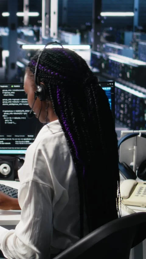 Vertical video System administrator in data center wearing headset assisting Stock Footage 313506597