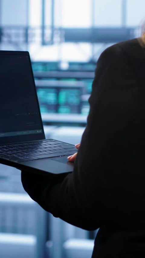 Vertical video System administrator in server farm using laptop to patch network Video stock 277857772