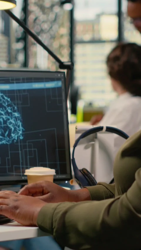 Vertical video System administrators brainstorming in office, using AI Stock Footage 323329832