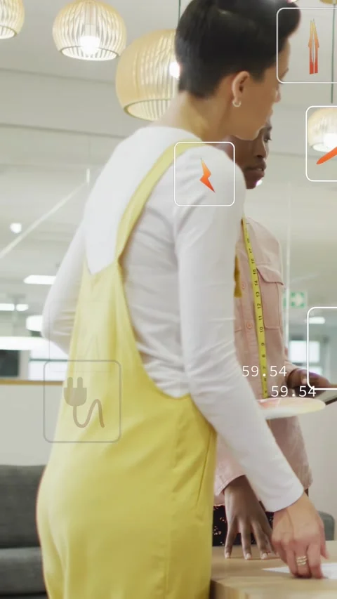 Vertical video: Tablet showing UI numbers causing designers consulting and Stock Footage 334396003