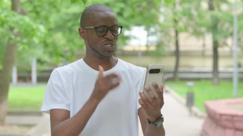 Vertical Video, Talking Young African Man Doing a Video Call Outdoors Video stock 310833167
