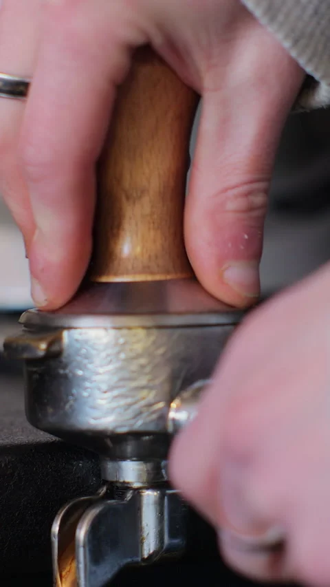 Vertical video. Tamping fresh ground coffee. Making fresh black coffee. Видео 344107448
