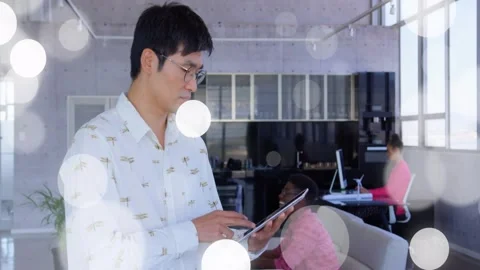 Vertical video: Tapping Korean man reviewing tablet in office, patterned shirt, Stock Footage 331161004