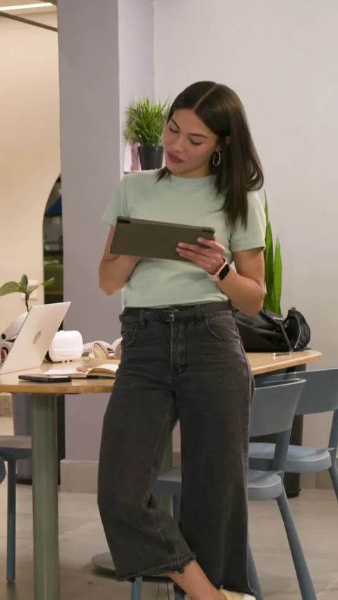 Vertical video: Tapping woman using tablet in office when peer opening laptop Stock Footage 348201986