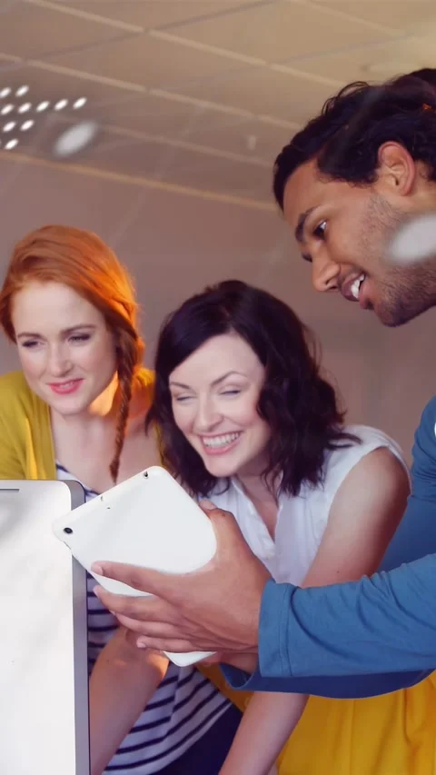Vertical video: Team angling tablet leaning in as code overlay fading across Stock Footage 332806977