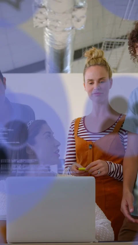 Vertical video: Team clustering laptop with dev tapping yellow phone causing Stock Footage 333692204
