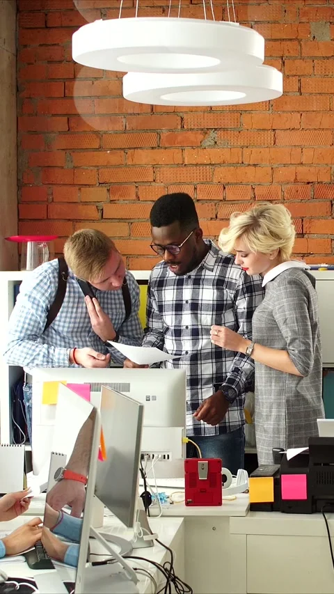 Vertical video of team collaborating around desktop computer in modern brick Stock Footage 323417461