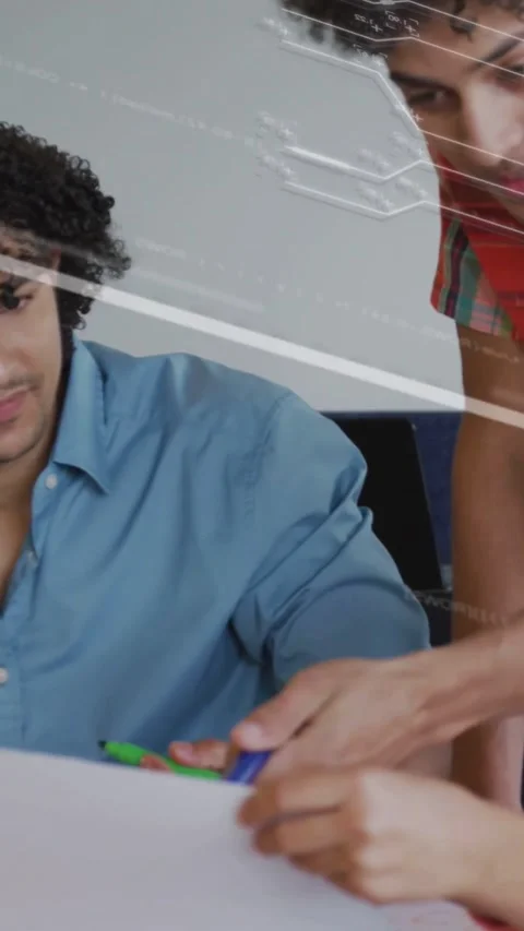 Vertical video: Team collaborating, one reaching and marking sheet while circuit Stock Footage 334544783