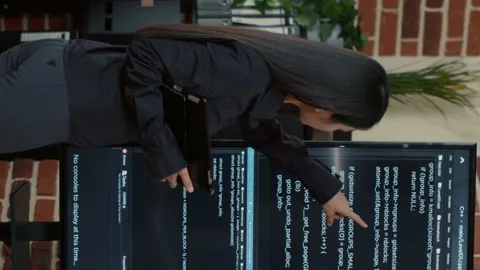 Vertical video Team of programmers analyzing code on wall screen tv looking for Stock Footage 194145499