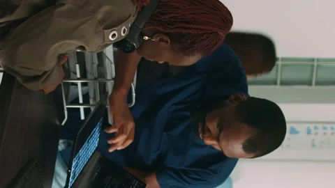 Vertical video: Team of programmers analyzing coding algorithms on laptop and Stock Footage 219702452