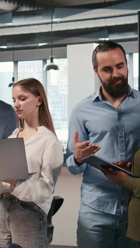 Vertical video Team of programmers in office automating repetitive tasks using Stock Footage 312768124