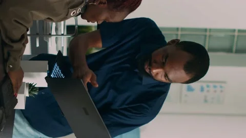 Vertical video: Team of software developers talking about source code running on Stock Footage 219702098