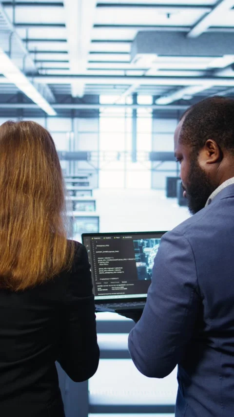 Vertical video Teamworking programmers in data center overseeing server Stock Footage 277857143