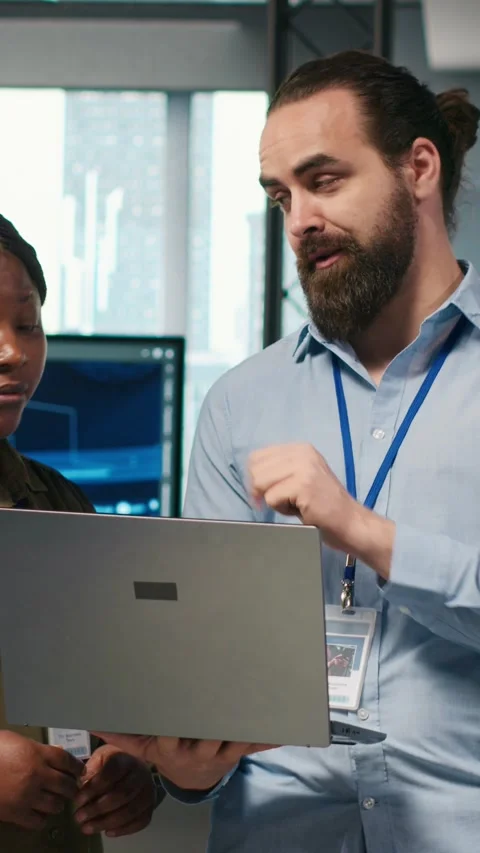 Vertical video Teamworking programmers in office reviewing AI system metrics Video stock 312708670