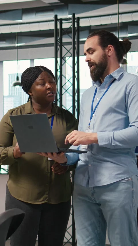 Vertical video Teamworking programmers in office reviewing AI system metrics Stock Footage 312709113