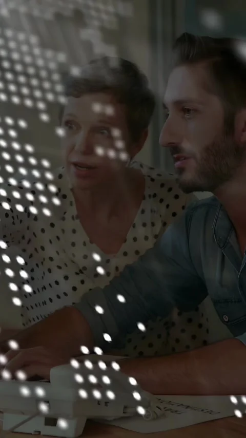 Vertical video: Tech code overlay thinning, woman pointing, man typing, Stock Footage 333135071