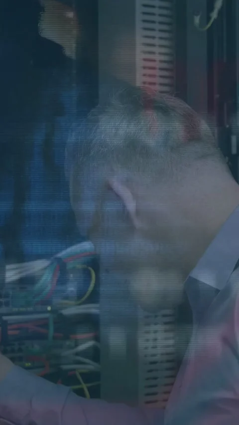 Vertical video: Tech seeing alert, adjusting rack cables to fix network while Stock Footage 332846255