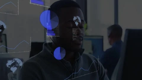 Vertical video: Tech sitting in headset at desk, charts appearing from left Stock Footage 333132218