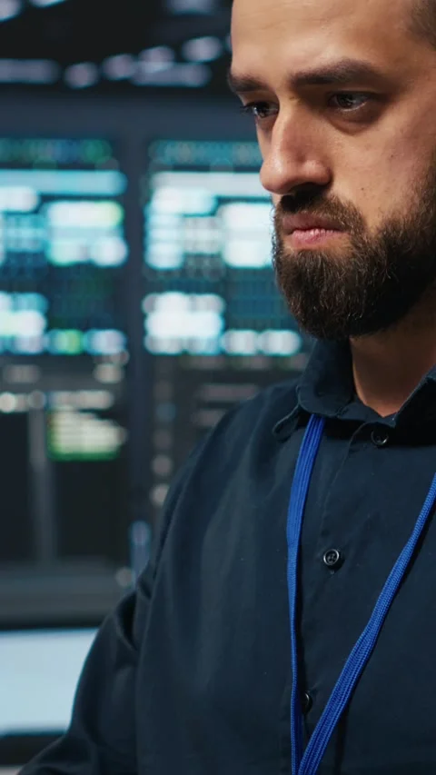 Vertical video Technician coding in high tech facility with server rows, close Stock Footage 274680648