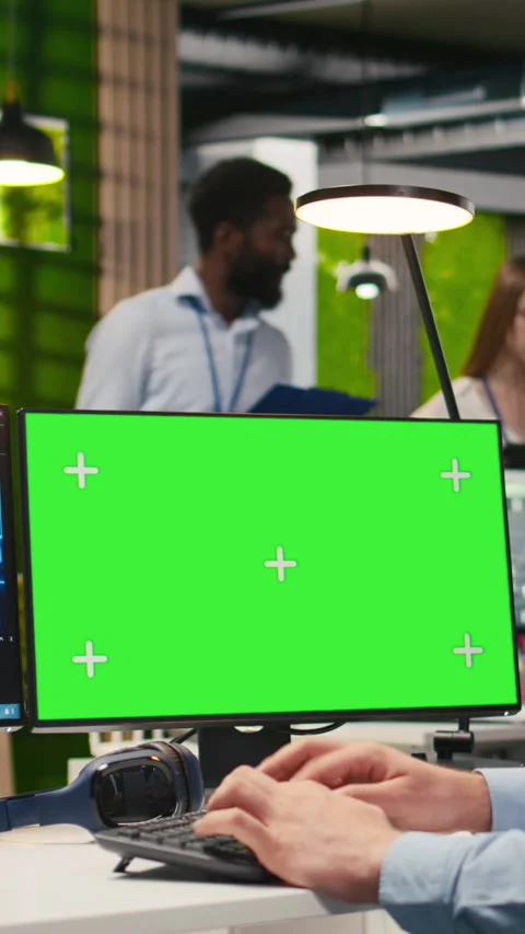 Vertical video Technician in office using green screen PC, automating repetitive Stock Footage 312709110