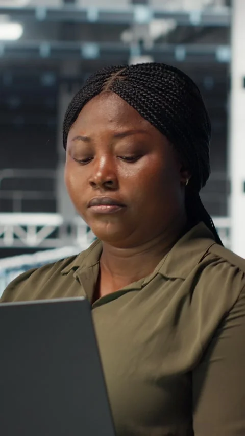 Vertical video Technician in server farm using laptop to upgrade rigs Stock Footage 316860388
